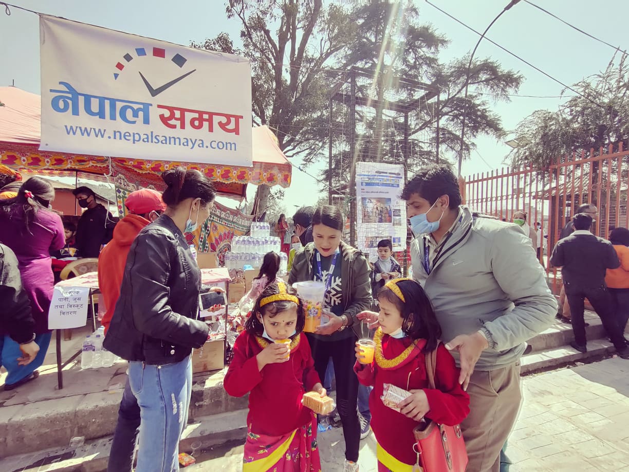 पशुपतिमा आउने भक्तजनलाई पानी र जुस खुवाउँदै नेपाल समय मिडिया