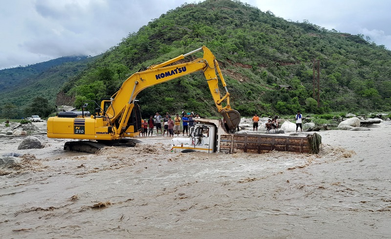 बाढी आएसँगै खोलाको बीचमा डुबेको टिपर