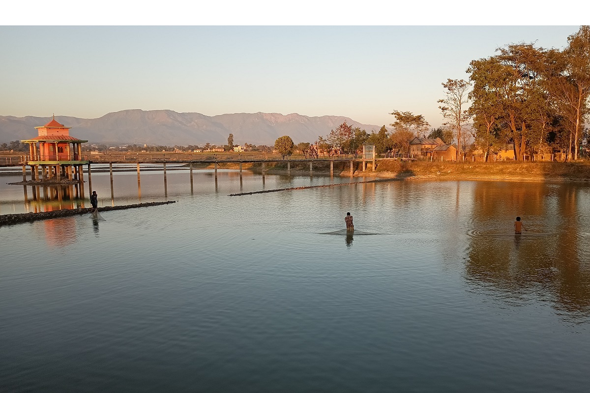 गौरी तालबाट माछा निकाल्दै एक युवा