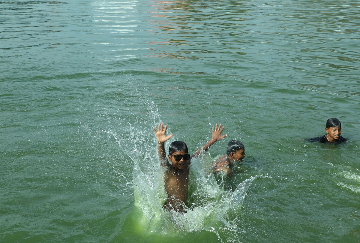 पोखरीमा पौडी खेल्दै बालक