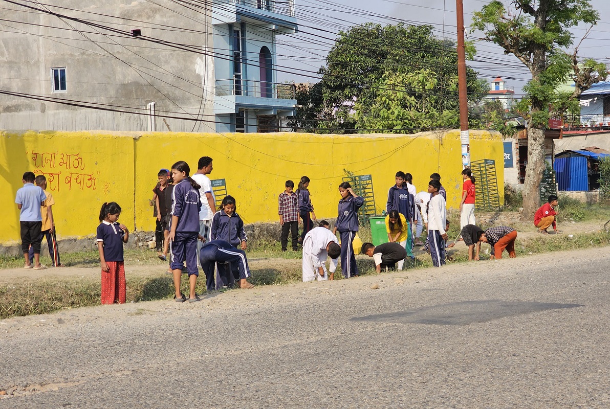 विद्यालय परिसरमा सरसफाइ गर्दै बालबालिका