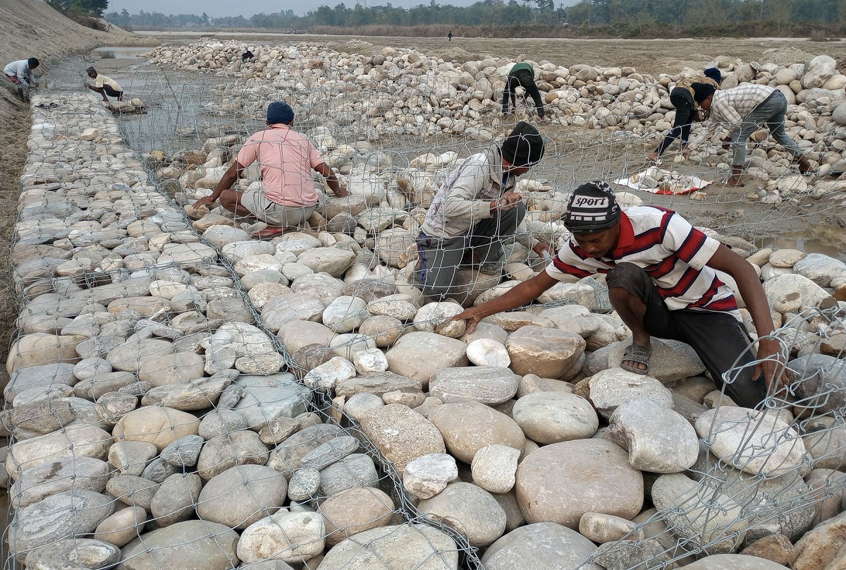 झापाको कमल खोलामा तटबन्धन निर्माणको काम गर्दै मजदुरहरु